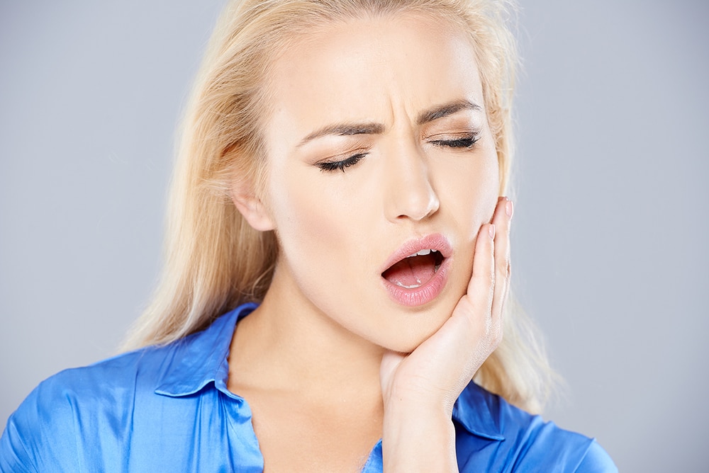 Woman experiencing mouth pain, emergency dentist, TRU Dentistry Austin